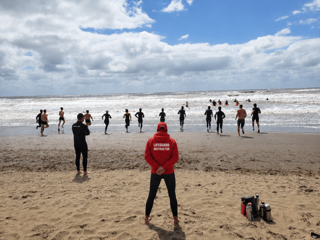 Instructor de guardavidas Aguaseguras con alumnos entrando al mar